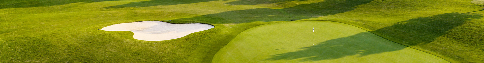 A stunning panoramic view of a well-maintained golf course featuring a putting green and sand bunker.